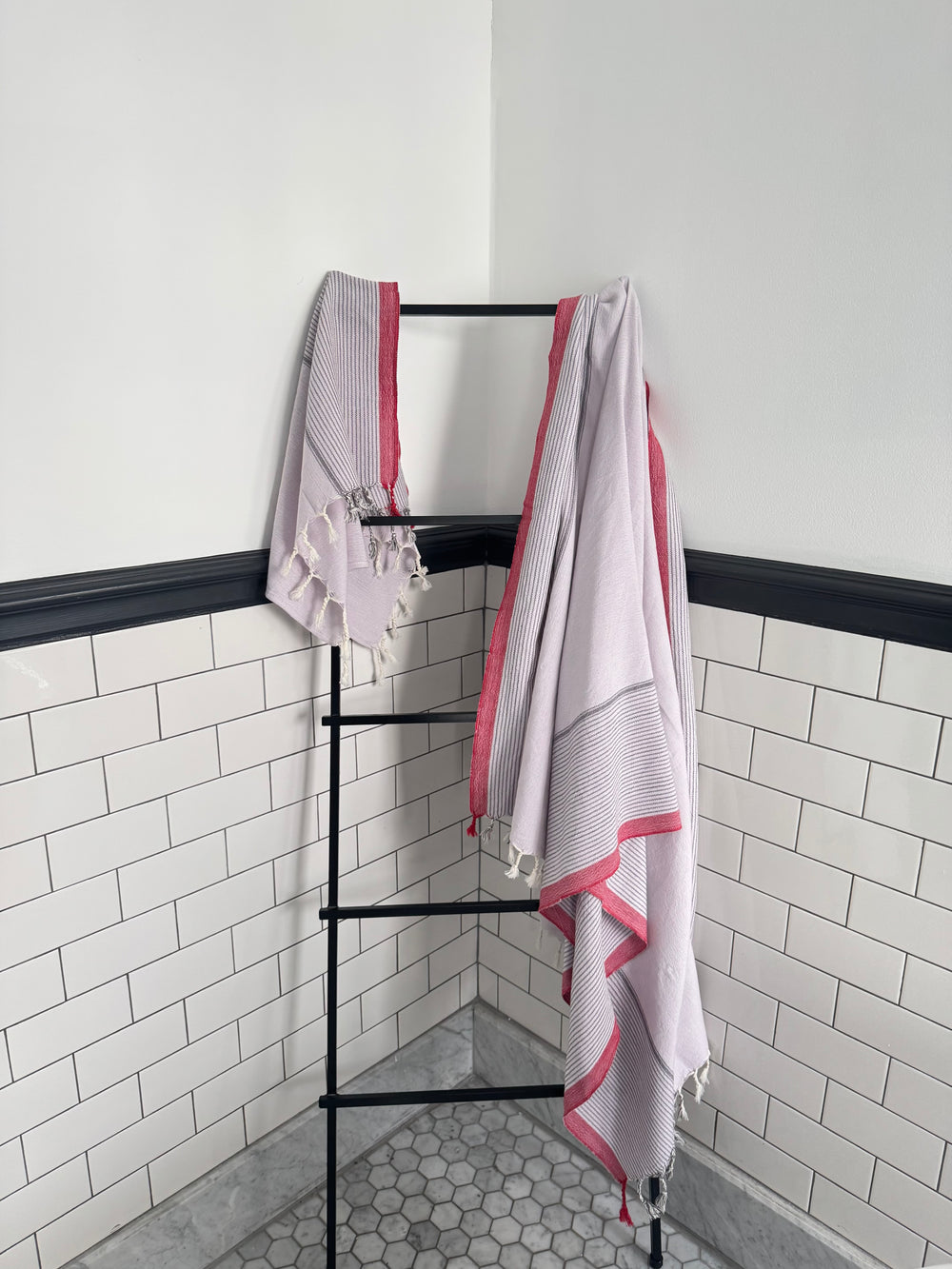 Home & Loft Rosewood_towel_hand_towel_combo hanging on ladder rack in white tiled bathroom