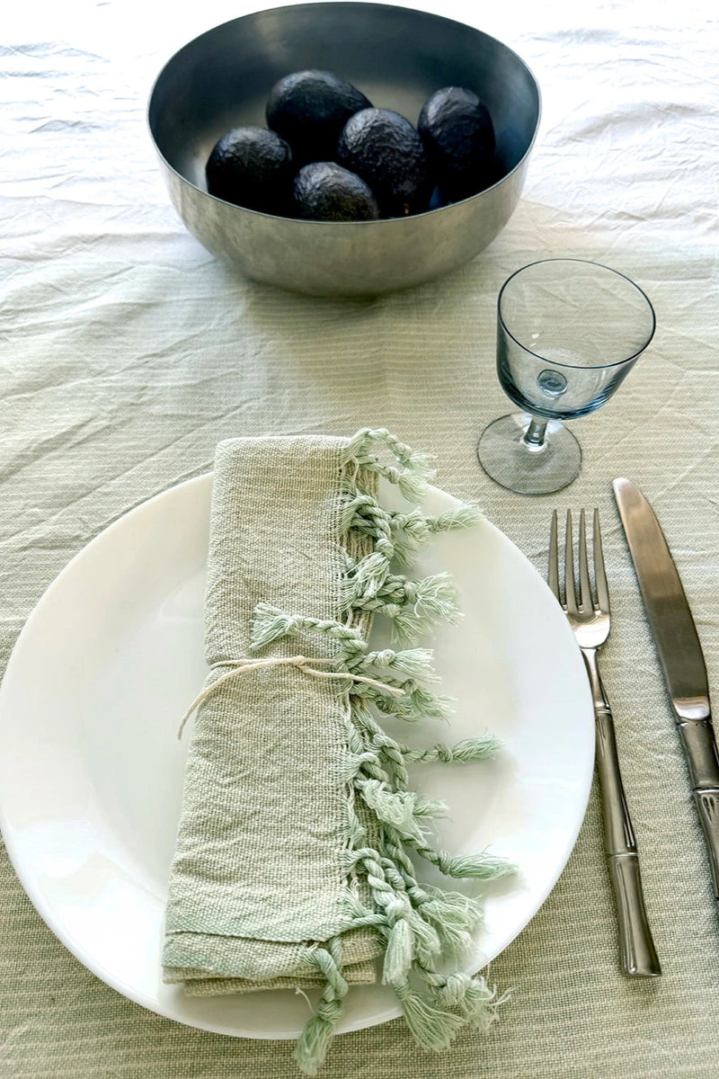 Home & Loft sage tonal tablecloth and hand towel napkin with bowl of avocados table setting
